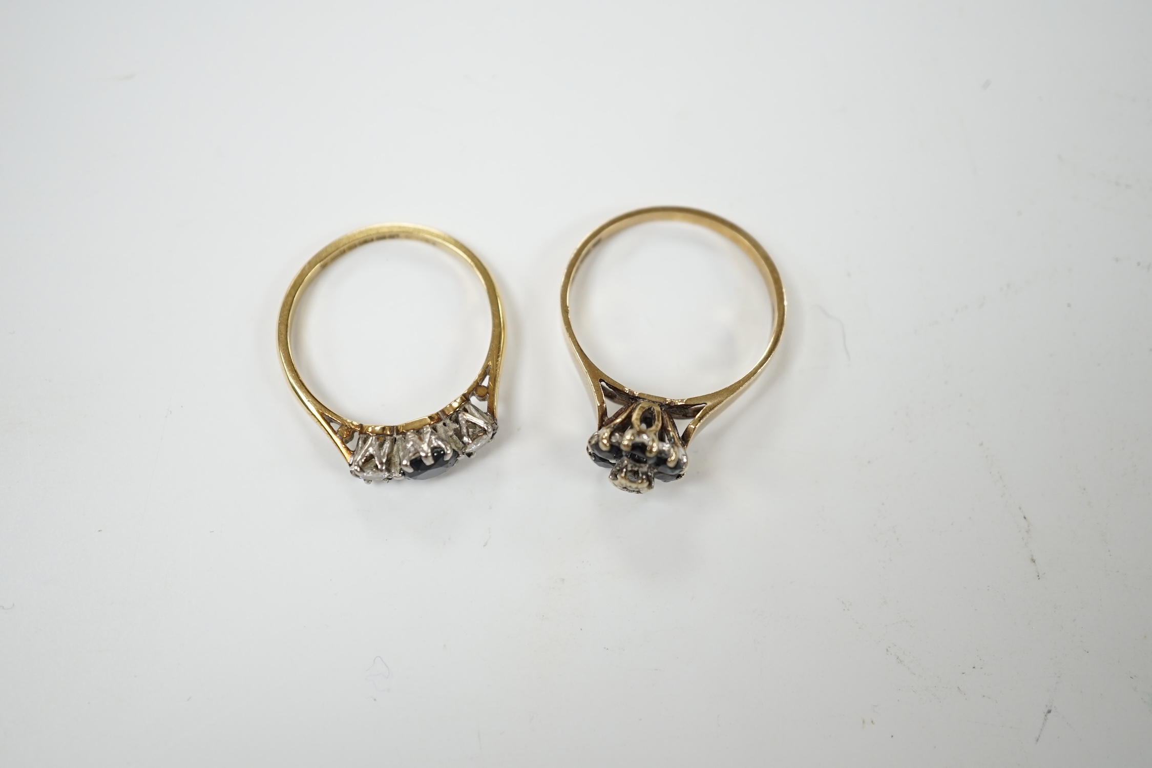 A modern 18ct gold, sapphire and diamond set three stone ring, size O, together with a similar 9ct gold, sapphire and diamond cluster set ring. Condition - fair